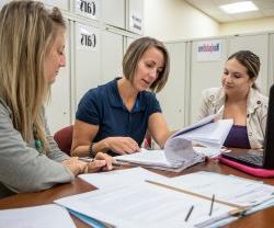 Faculty and staff discussing charts