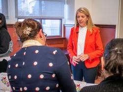 Valeria Aloe stands at a table talking with students.